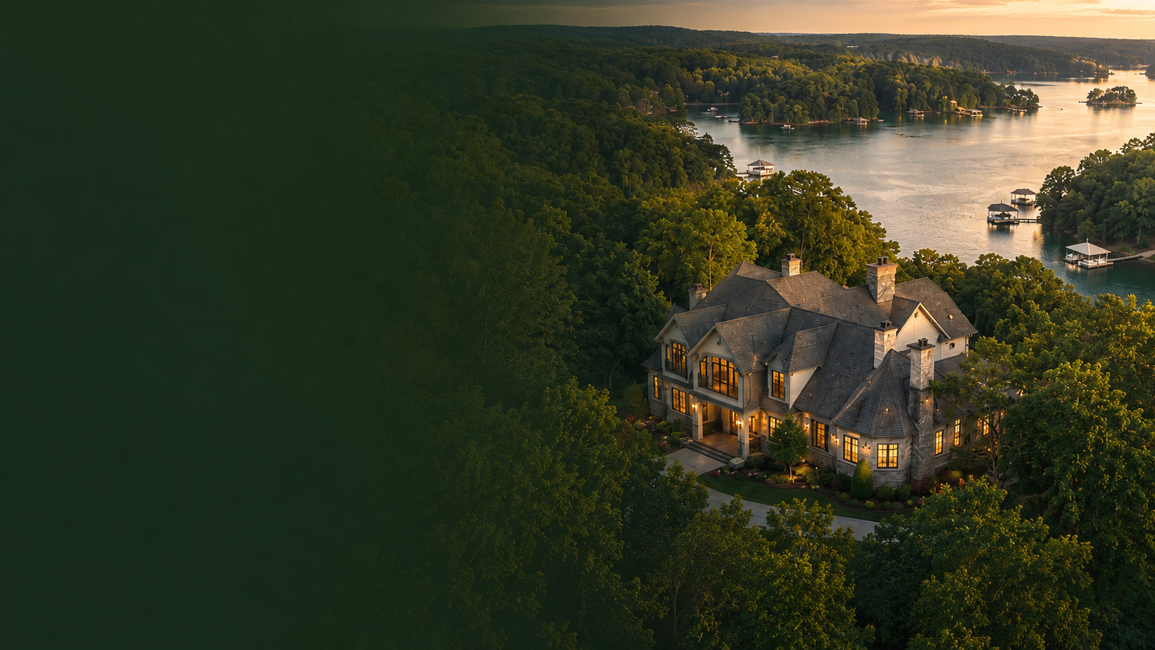 Aerial view of a large lakefront estate on the wooded shoreline of Lake Lanier at sunset